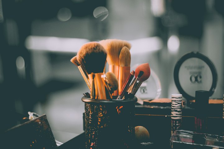A cup of makeup brushes on a dressing table