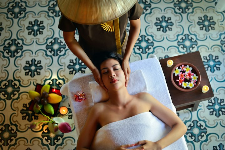 Overhead view of a client receiving a relaxing head and face massage