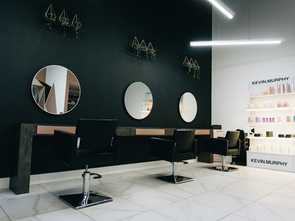 A minimal workspace with black styling chairs and round mirrors