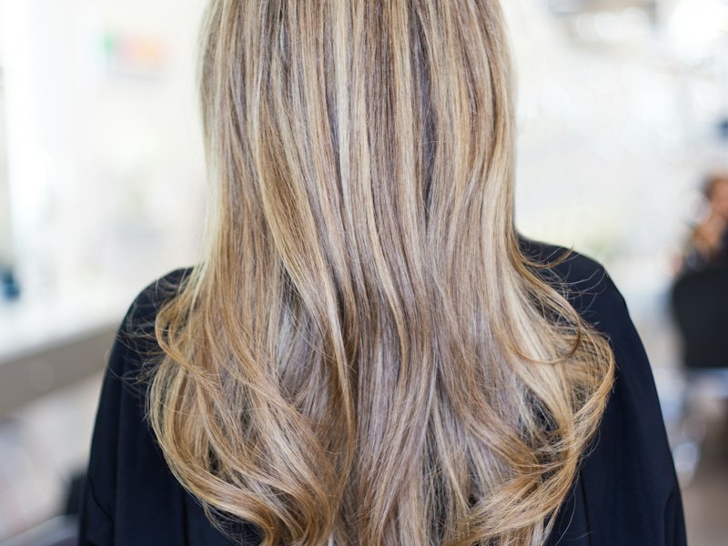 Long hair with soft, blended honey-blonde colour seen from behind