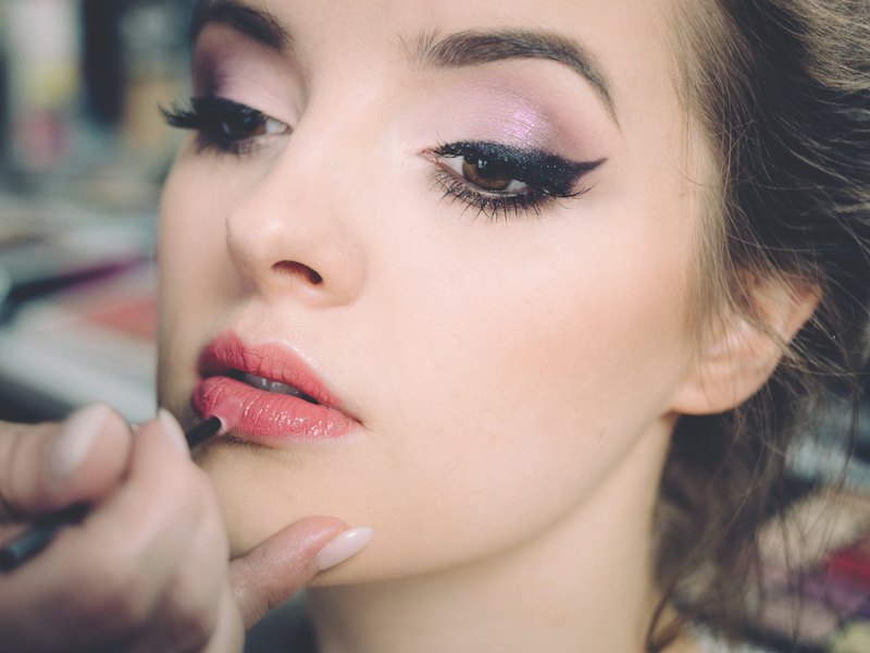 Close-up of lip colour being applied with a fine brush